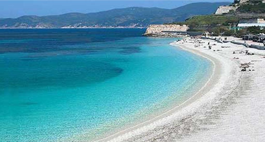 a beach with a group of people and the ocean at Bell'appartamento in Portoferraio