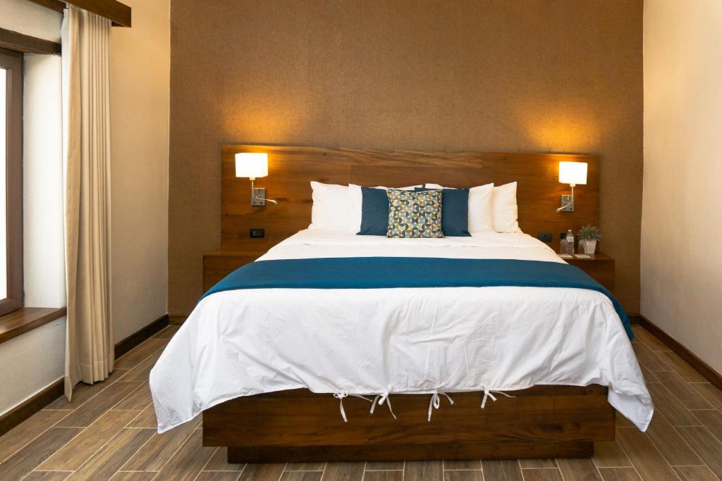 - une chambre dotée d'un grand lit avec des draps et des oreillers blancs dans l'établissement Casa Villamil Boutique Hotel, à Copan Ruinas