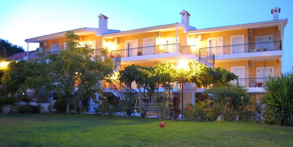 a large building with a lawn in front of it at Odyssia Apartments in Katelios