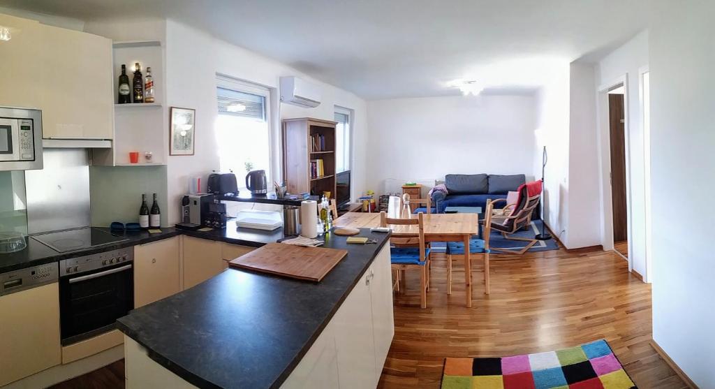 eine Küche und ein Wohnzimmer mit einem Tisch in der Unterkunft Family-friendly flat with balcony in Wien