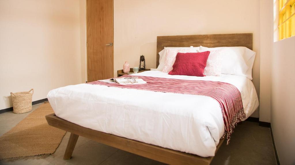 a bedroom with a large bed with red pillows at Cactus Hostel & Suites in Guanajuato