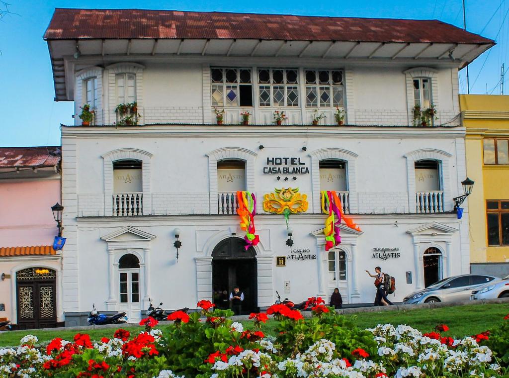 Biały budynek z kwiatami przed nim w obiekcie Hotel Casablanca w mieście Cajamarca