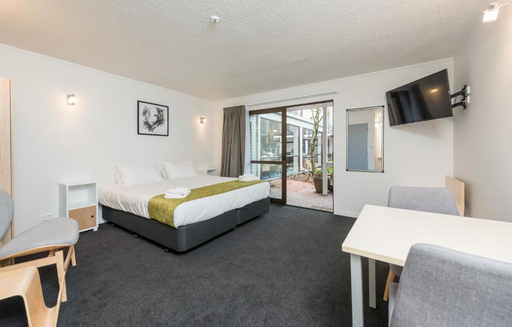 um quarto de hotel com uma cama e uma televisão em Queen Street Studios em Richmond