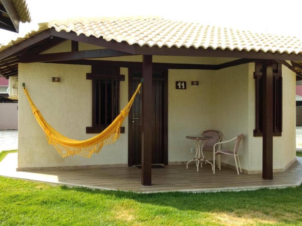 um pátio com uma rede de descanso anexada a uma casa em Mamelucos Chalé 11 Praia do Flamengo em Salvador