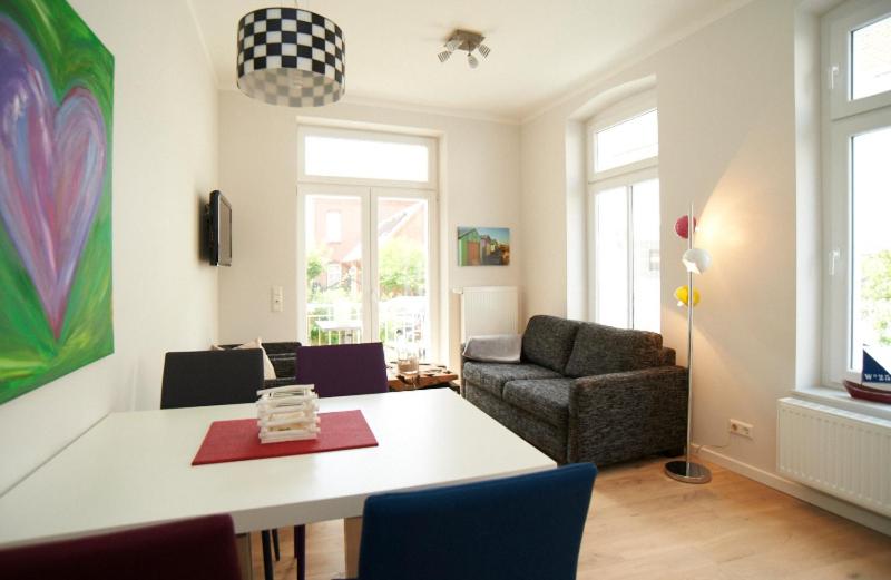 - un salon avec une table et un canapé dans l'établissement Apartment Eisberg 2 mit Balkon, à Norderney