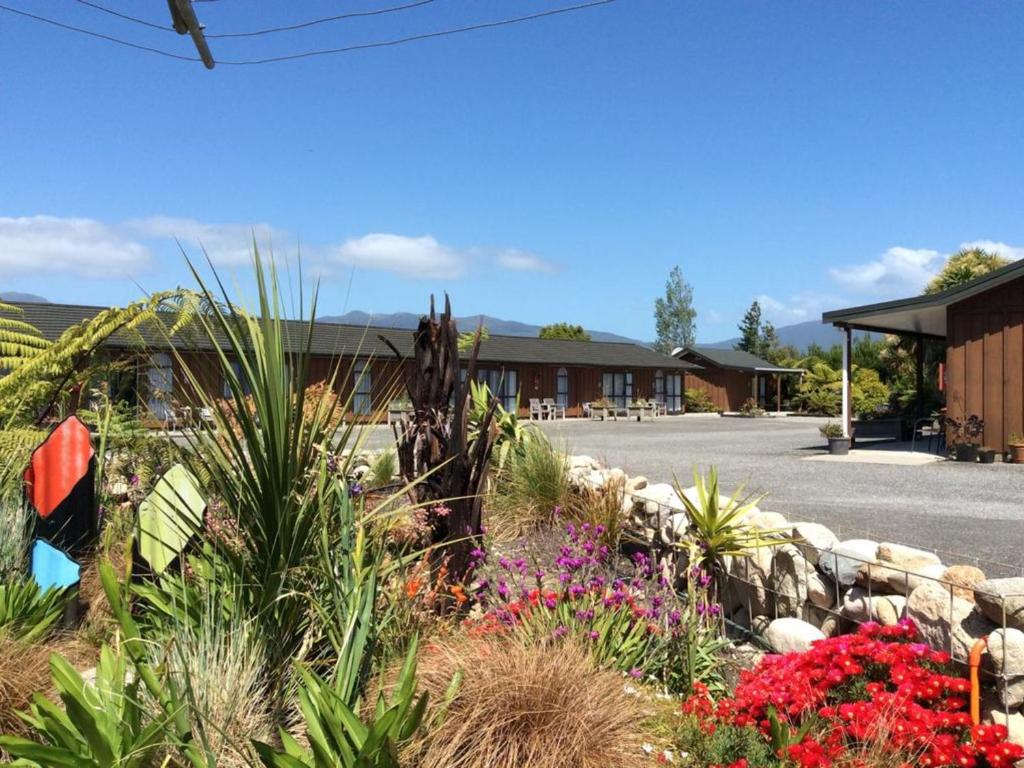 un giardino fiorito di fronte a un edificio di Buller Bridge Motel a Westport