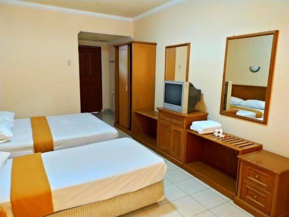 Postel nebo postele na pokoji v ubytování HOTEL & WISMA BINTANG JADAYAT