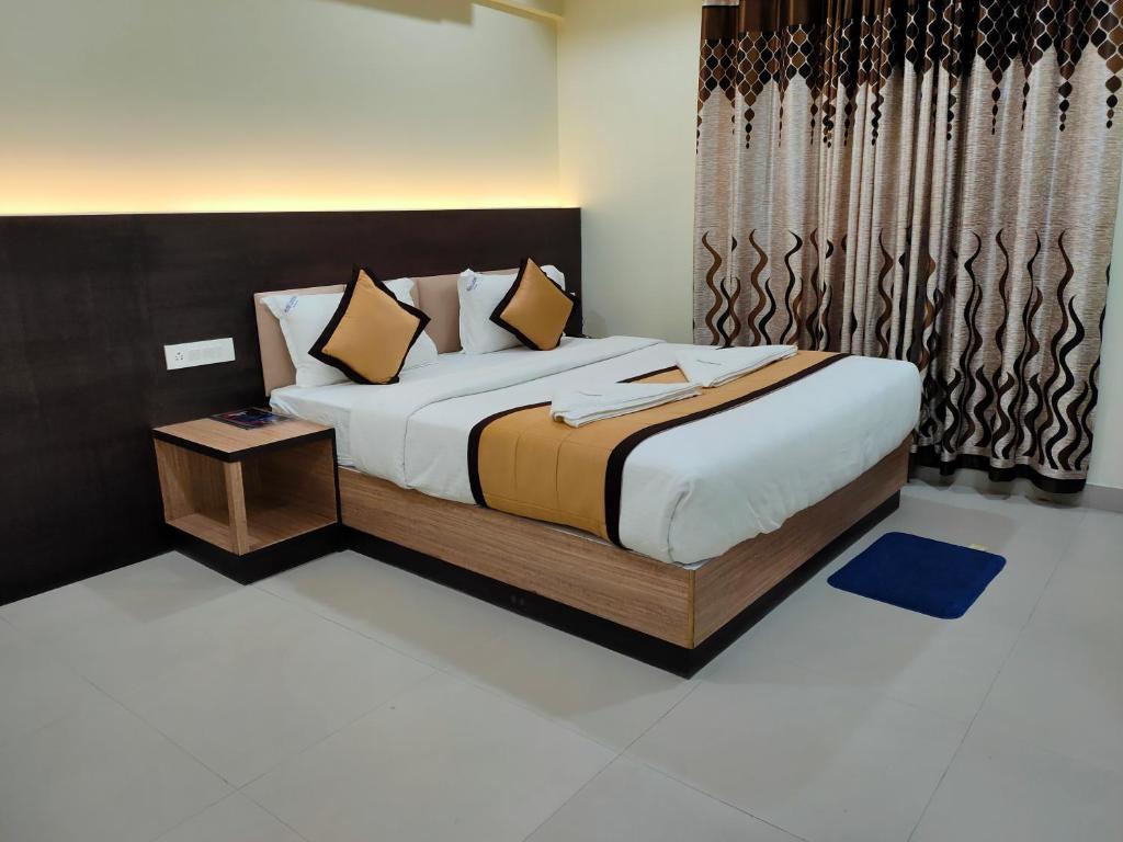 a bedroom with a large bed with a wooden headboard at Hotel Landmark in Port Blair