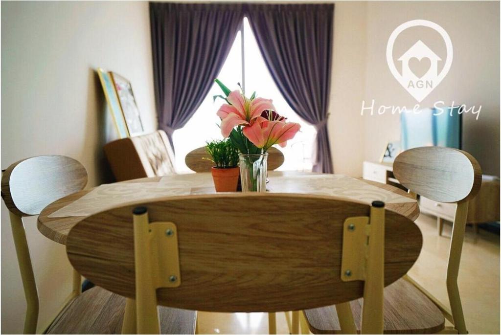 a wooden table with flowers on it in a dining room at AMAZING SEAVIEW @ SILVERSCAPE in Melaka