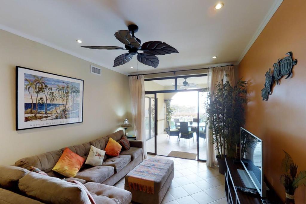 a living room with a couch and a ceiling fan at Sunrise 22 in Tamarindo