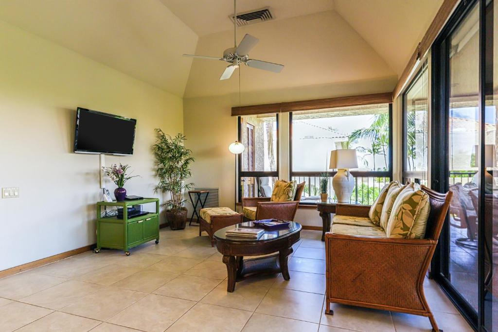 sala de estar con muebles y TV de pantalla plana. en Shores at Waikoloa #338 en Waikoloa