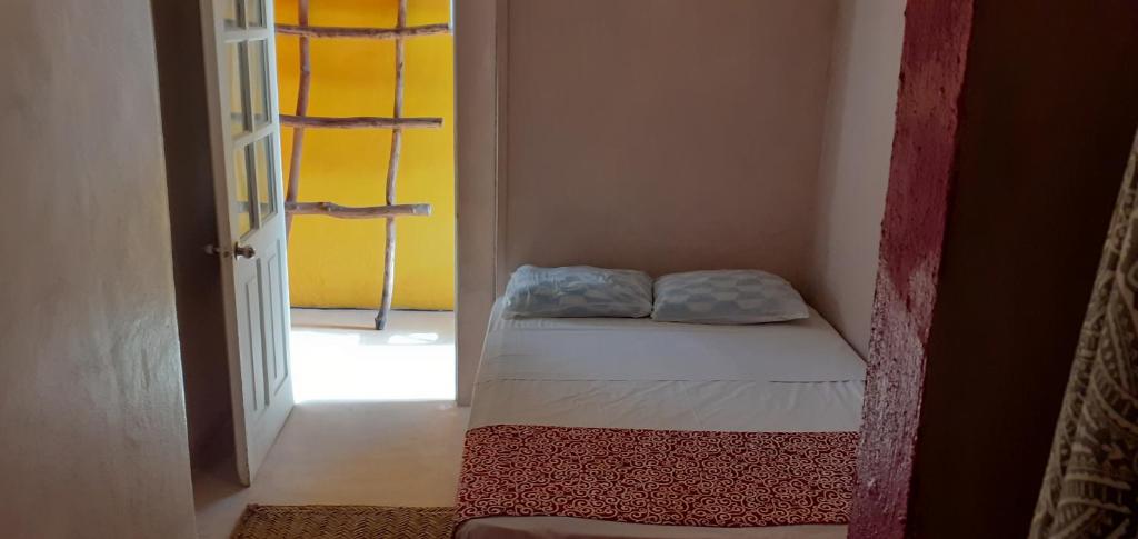 a small bedroom with a bed in a room at Lola Atlachinolli in Sayulita