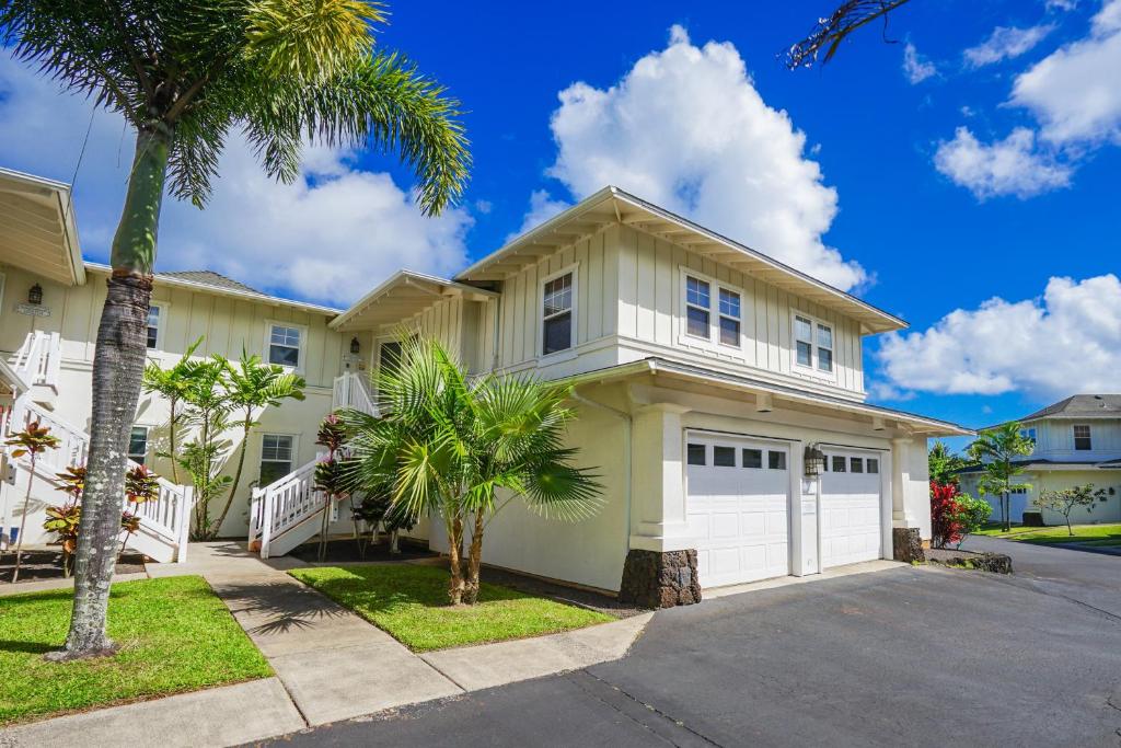 a house with a garage and a palm tree at Plantations at Princeville #1312 in Princeville