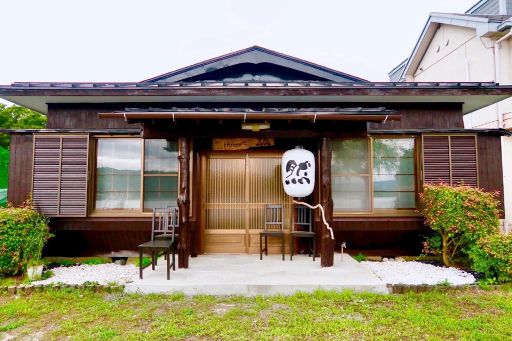 Una casa con un letrero en la parte delantera. en Guest House Zen en Yamanakako