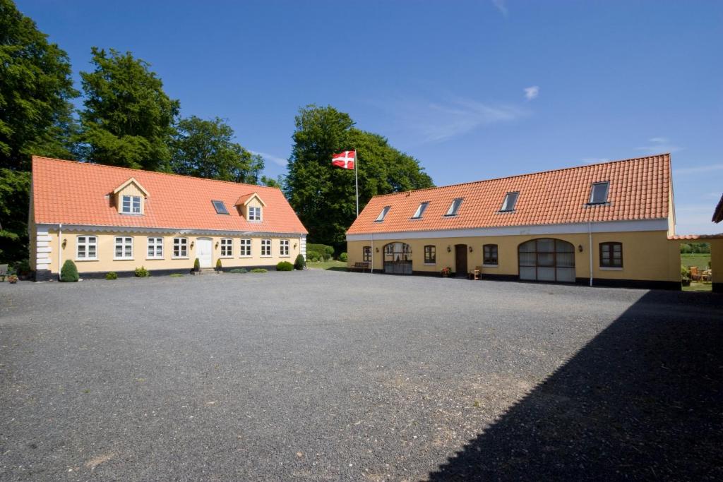 two white buildings with red roofs and a driveway at Munkebjerg Bed & Breakfast in Børkop