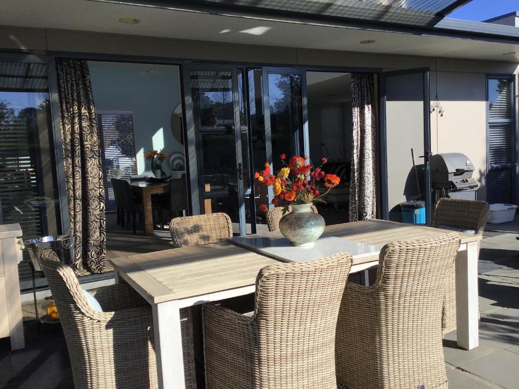 a table with chairs and a vase with flowers on it at The Gallery in Taupo