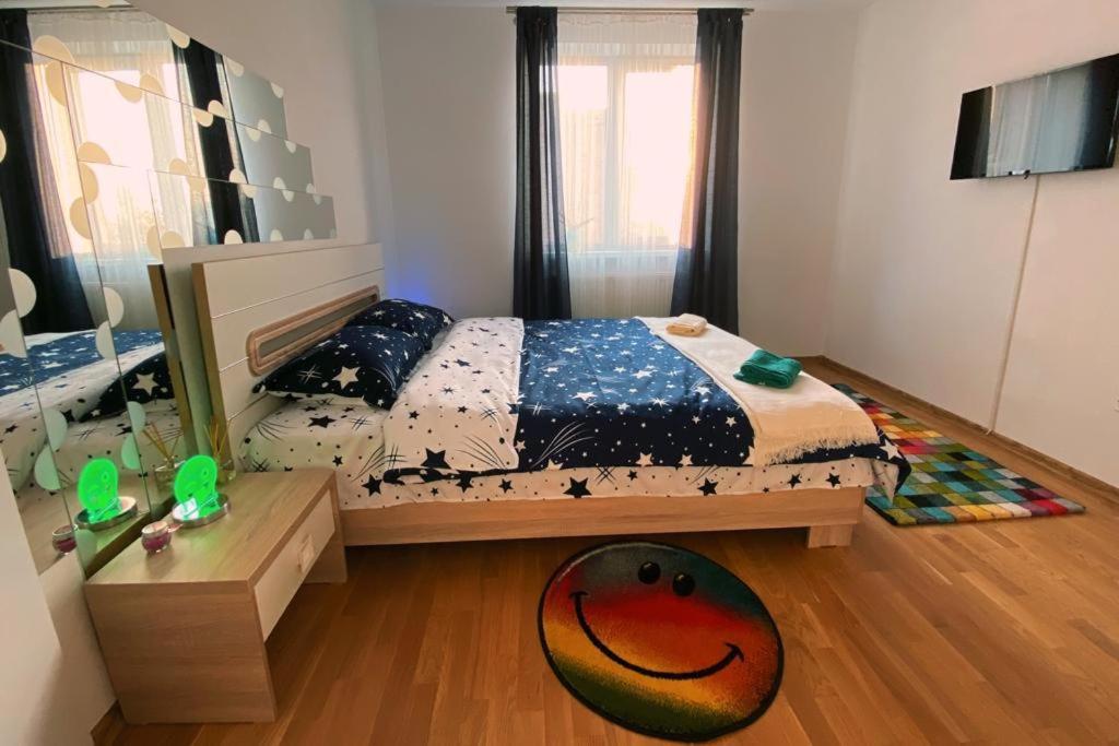 a bedroom with a bed and a wooden floor at Apartament Smiley in Sighişoara