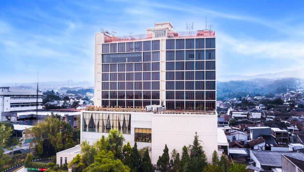 a tall white building with windows on top of a city at PRIME PARK Hotel Bandung in Bandung
