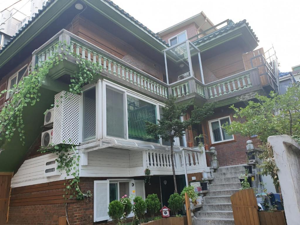 ein Haus mit einem Balkon auf der Vorderseite in der Unterkunft Ok guesthouse in Seoul