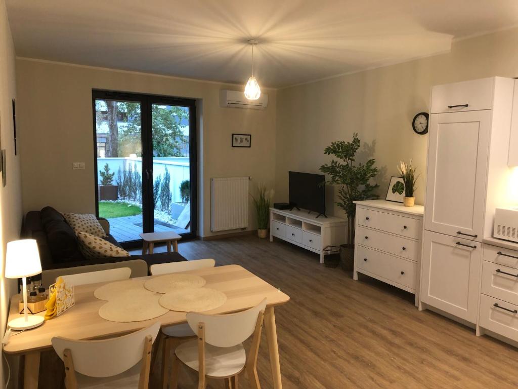 uma cozinha e sala de estar com uma mesa e um sofá em Wislane Tarasy 2.0 by Atrium Apartments em Cracóvia