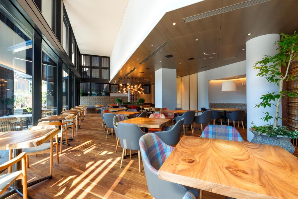 金沢市にあるホテルフォルツァ金沢 の木製のテーブルと椅子が備わるレストラン