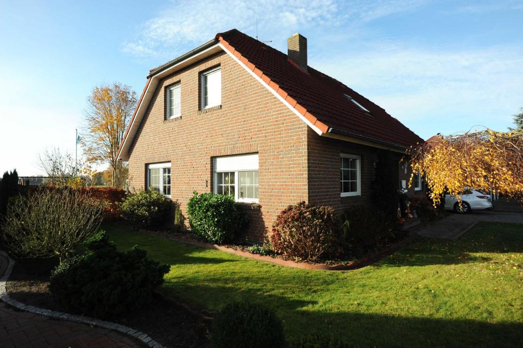 a brown brick house with a grass yard at Ferienwohnung Nordbrock, 65317 in Moormerland
