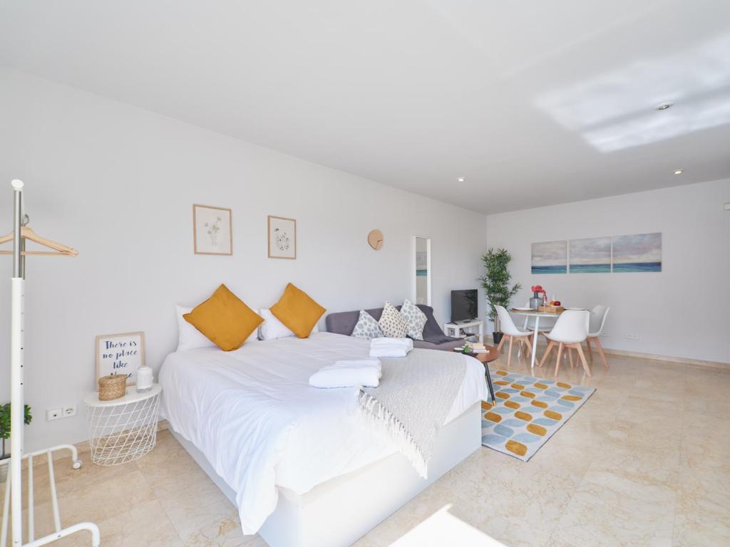 1 dormitorio blanco con 1 cama grande y sala de estar en My City Home - Estudio Legazpi con terraza y piscina comunitaria, en Madrid