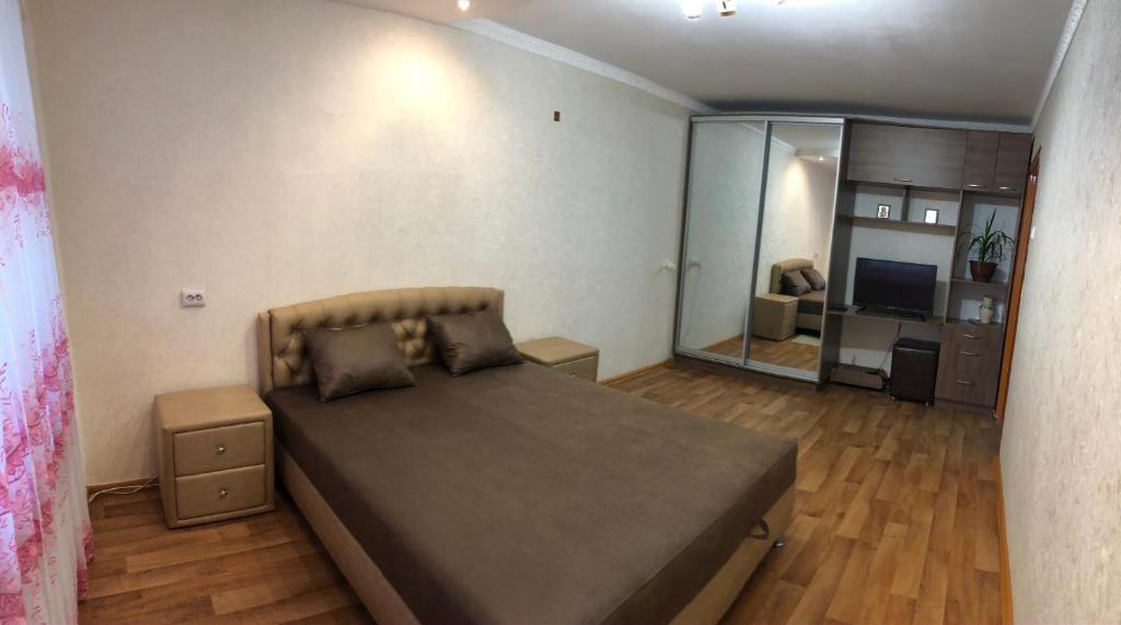 een slaapkamer met een groot bed en een woonkamer bij Apartment Shevchenka 154 in Nikopol