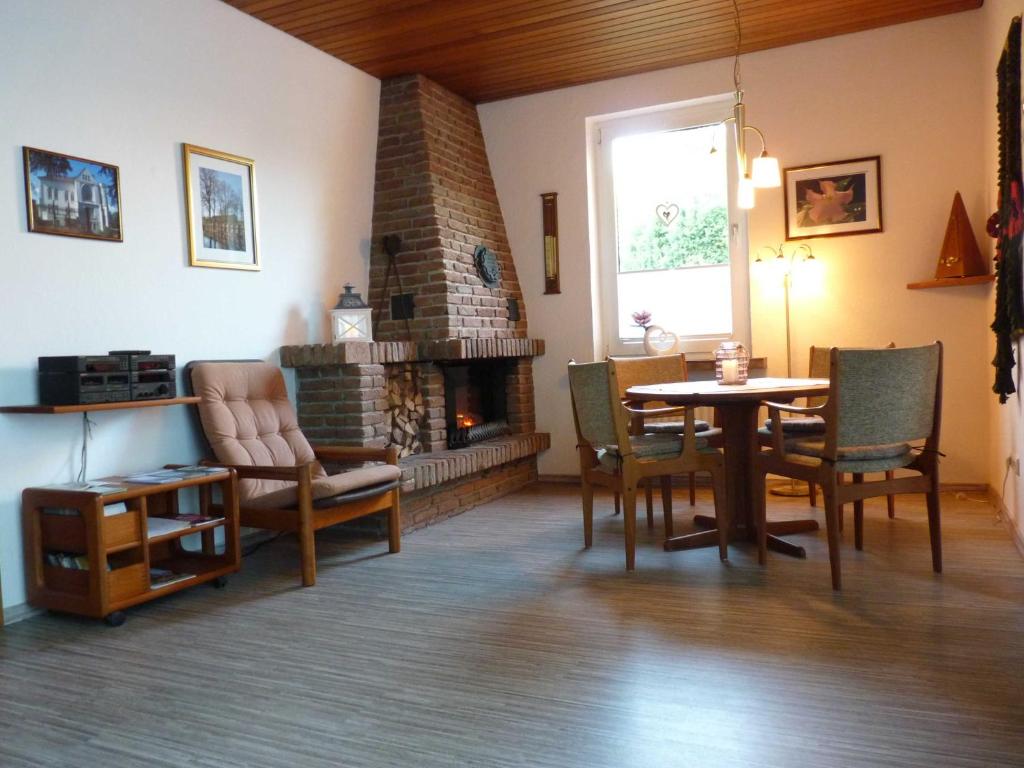 a living room with a table and a fireplace at Ferienwohnung Loquard, 15168 in Leer