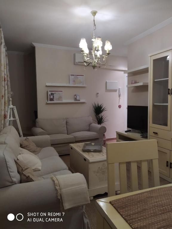 a living room with a couch and a chandelier at Apartamento Las Musas in Santiponce