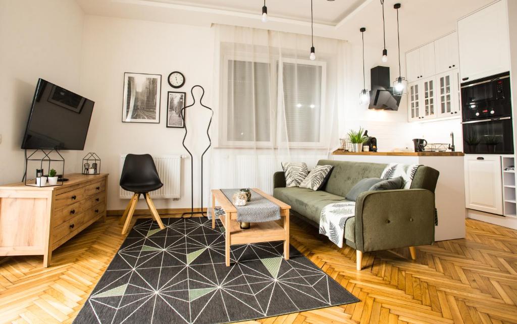 uma sala de estar com um sofá e uma televisão em Apartament MANSARDA em Września