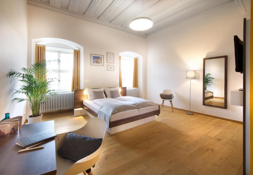 Pokój hotelowy z łóżkiem i biurkiem w obiekcie JUFA Hotel Kronach – Festung Rosenberg w mieście Kronach
