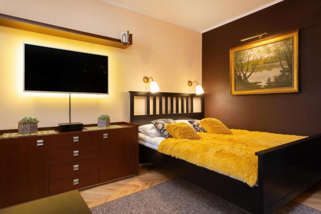 um quarto com uma cama e uma televisão de ecrã plano em Apartments Warsaw Świętojańska by Renters em Varsóvia