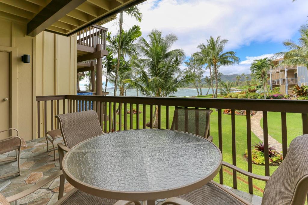 een tafel en stoelen op een balkon met uitzicht op de oceaan bij Lae Nani 326 in Kapaa