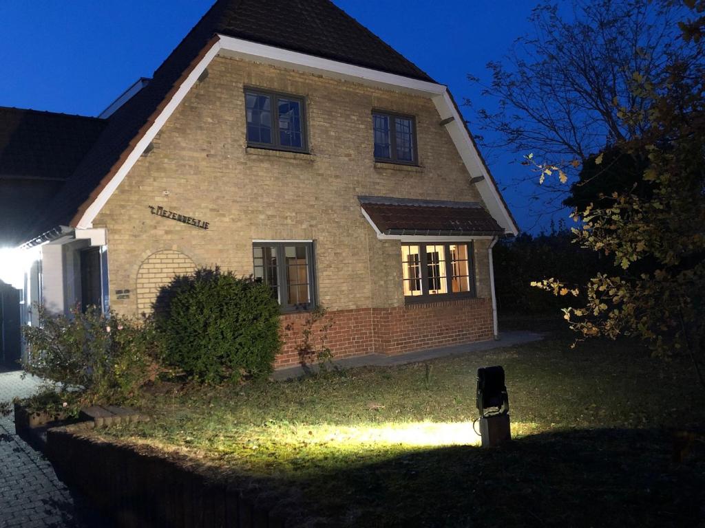 una casa con una luz delante de ella por la noche en villa mezennestje en Oostduinkerke