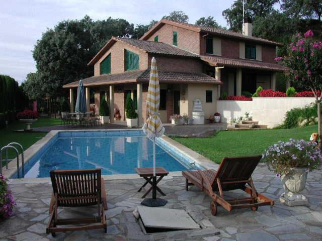 ein Haus mit Pool und zwei Stühlen und einem Haus in der Unterkunft LA DEVESA in Azanúy