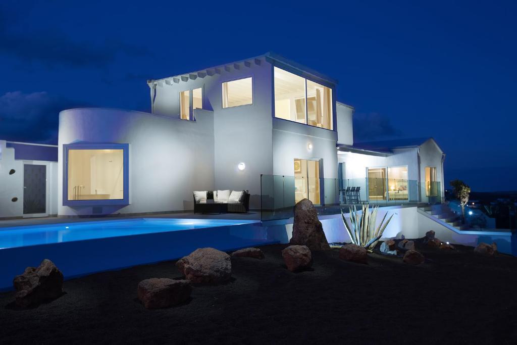 a villa with a swimming pool at night at The view lanzarote in Mácher