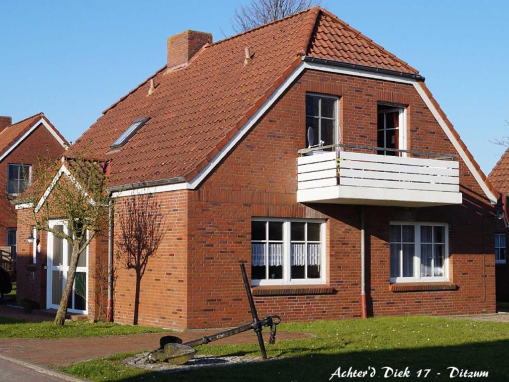 una casa in mattoni con balcone sopra di Ferienwohnung Achter`d Diek, 45183 a Jemgum