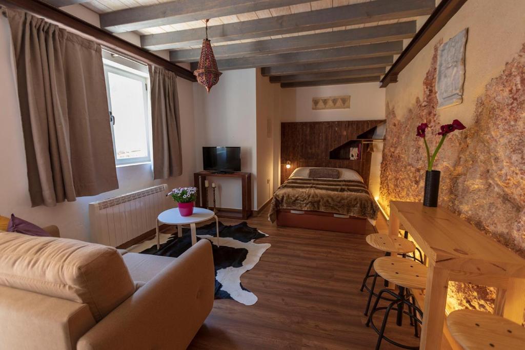 uma sala de estar com uma cama e um sofá em Domus Lapidis - El Taller em Bogarra
