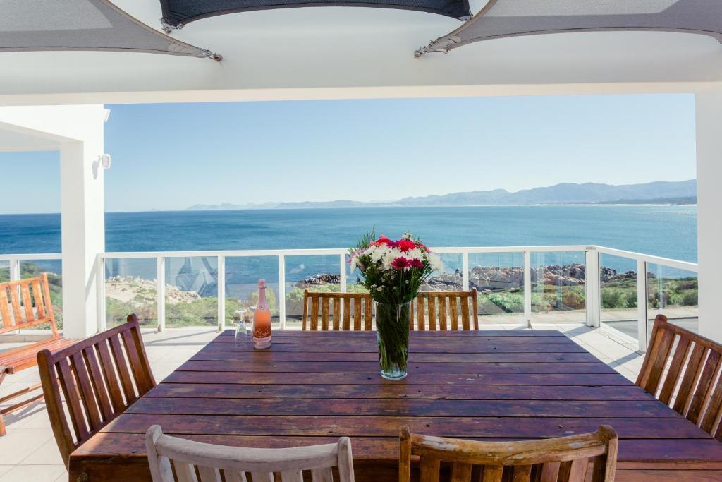 a dining room table with a vase of flowers on it at 49 on Cliff in Gansbaai