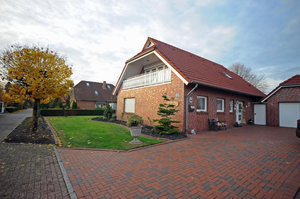 a red brick house with a brick driveway at Ferienwohnung Schilling_ 65043 in Moormerland