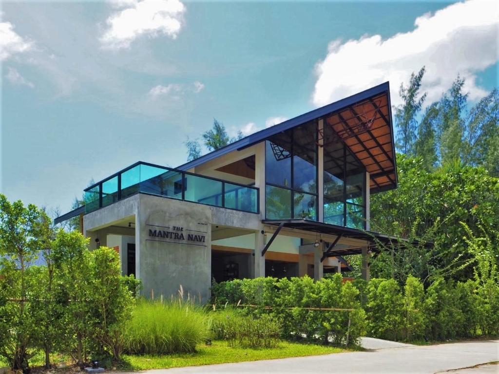 a house with glass windows and a roof at The Mantra Navi in Ko Lanta