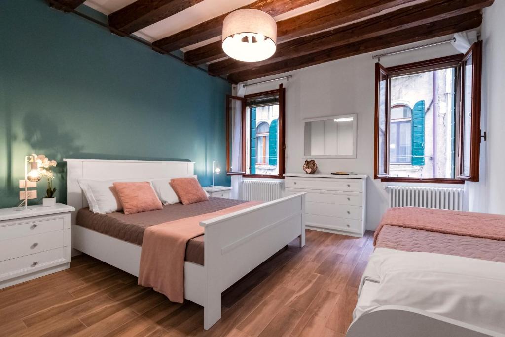 een slaapkamer met 2 bedden en 2 ramen bij Dorsoduro Suite 1241 in Venetië