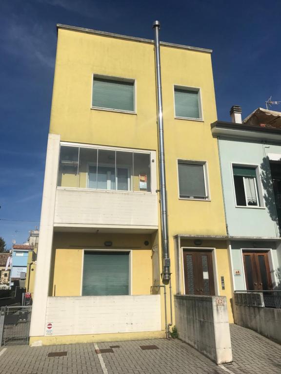 un edificio amarillo con ventanas en una calle en Appartamento Fano zona lido, en Fano