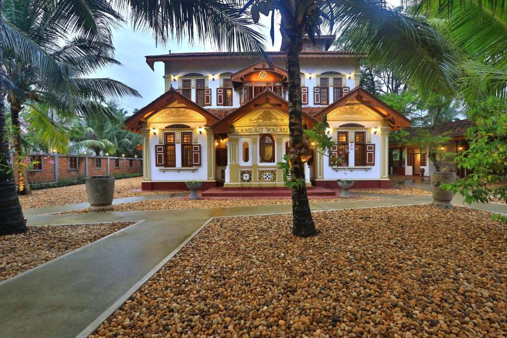 a house with a palm tree in front of it at Sandali Walauwa in Bentota