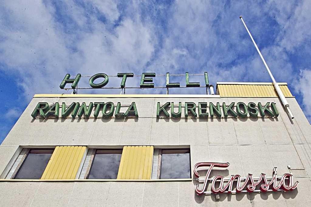um edifício com um sinal em cima em hotelli ravintola kurenkoski em Pudasjärvi