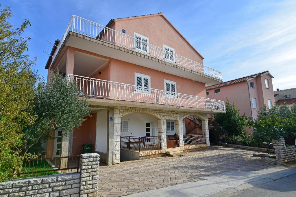 a large house with a balcony on top of it at Apartments Martina in Vodice