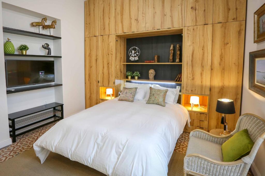 1 dormitorio con 1 cama blanca y 2 sillas en A ESCONDIDASs, en Ayamonte