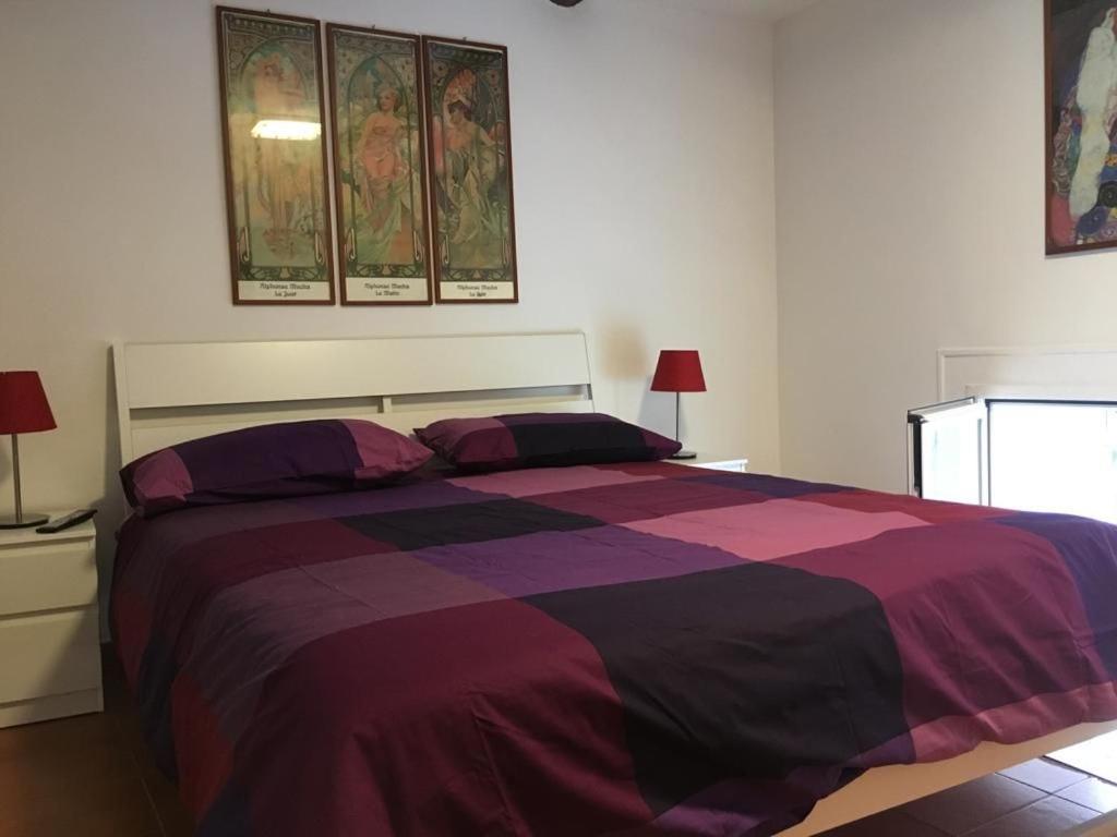 a bedroom with a large bed with a purple blanket at MIDA HOUSE in Naples