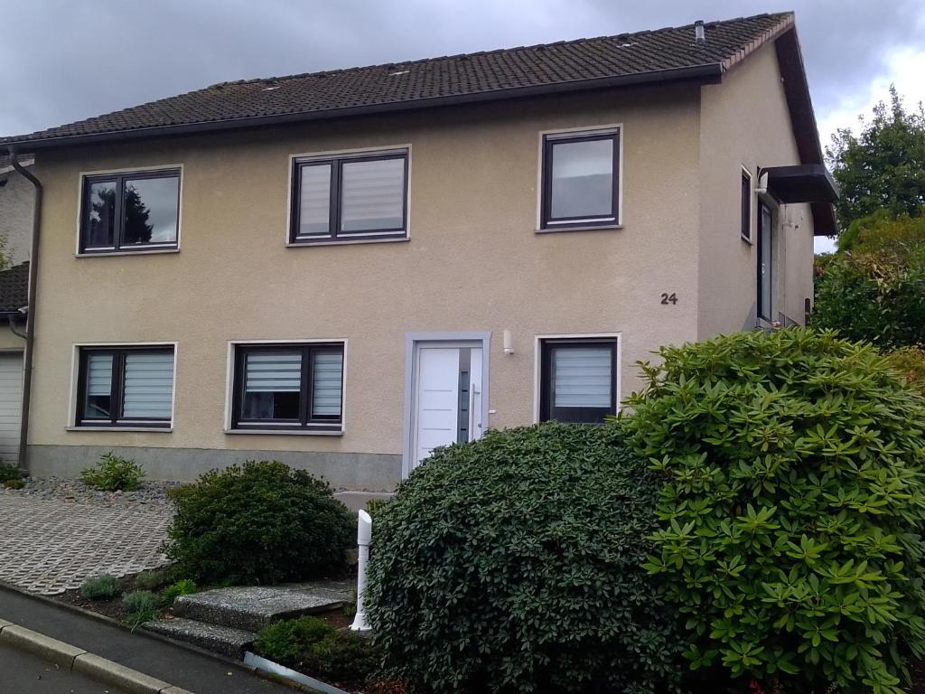 una casa con ventanas negras y un arbusto en Haus Sonnenschein, en Wermelskirchen